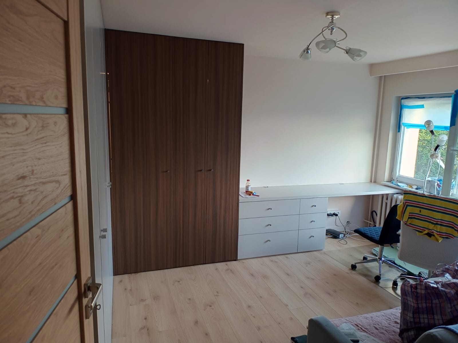 Pokój z drewnianą zabudową i jasną podłogą.