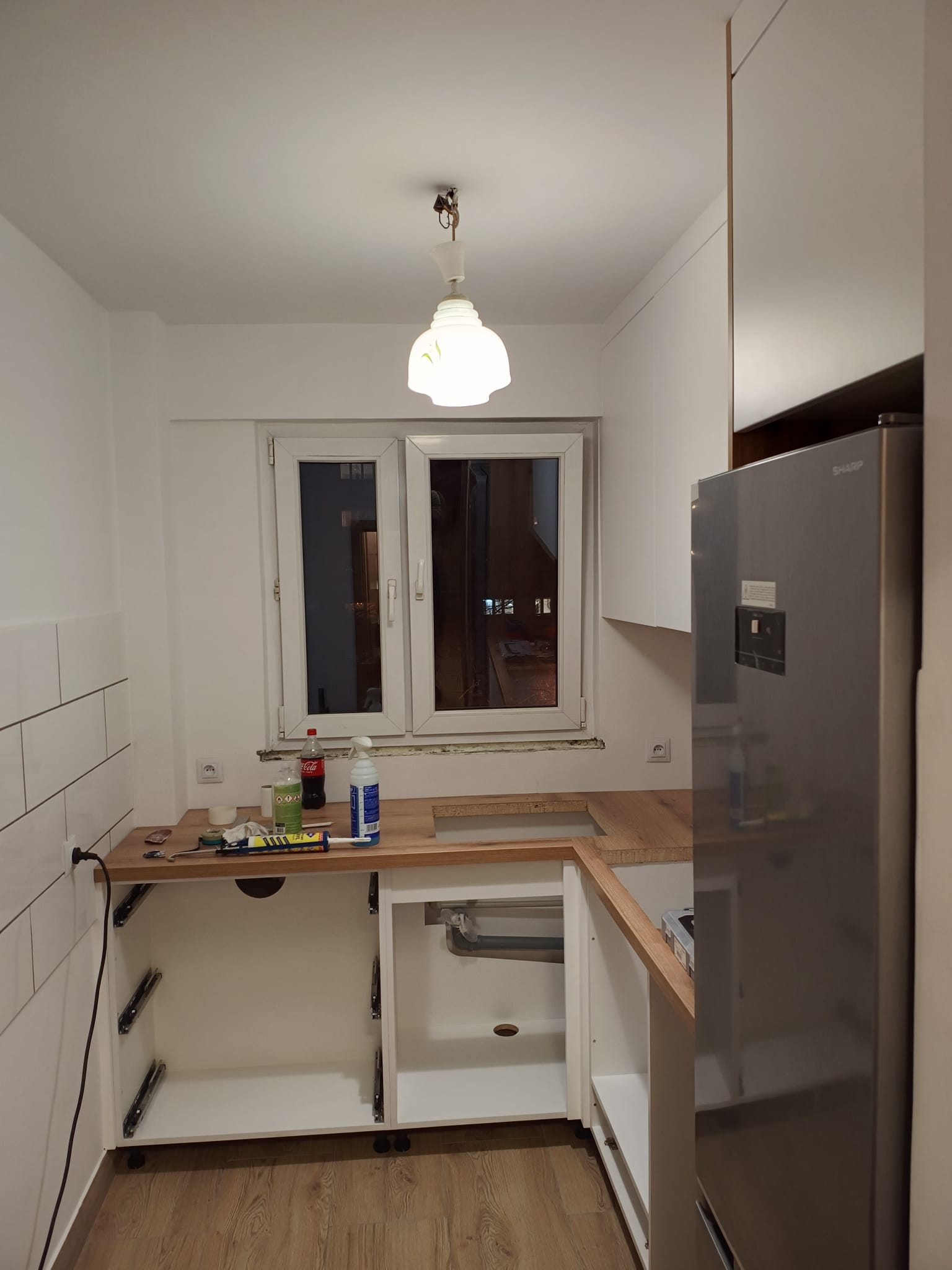 Kuchnia w trakcie montażu z otwartymi szafkami.