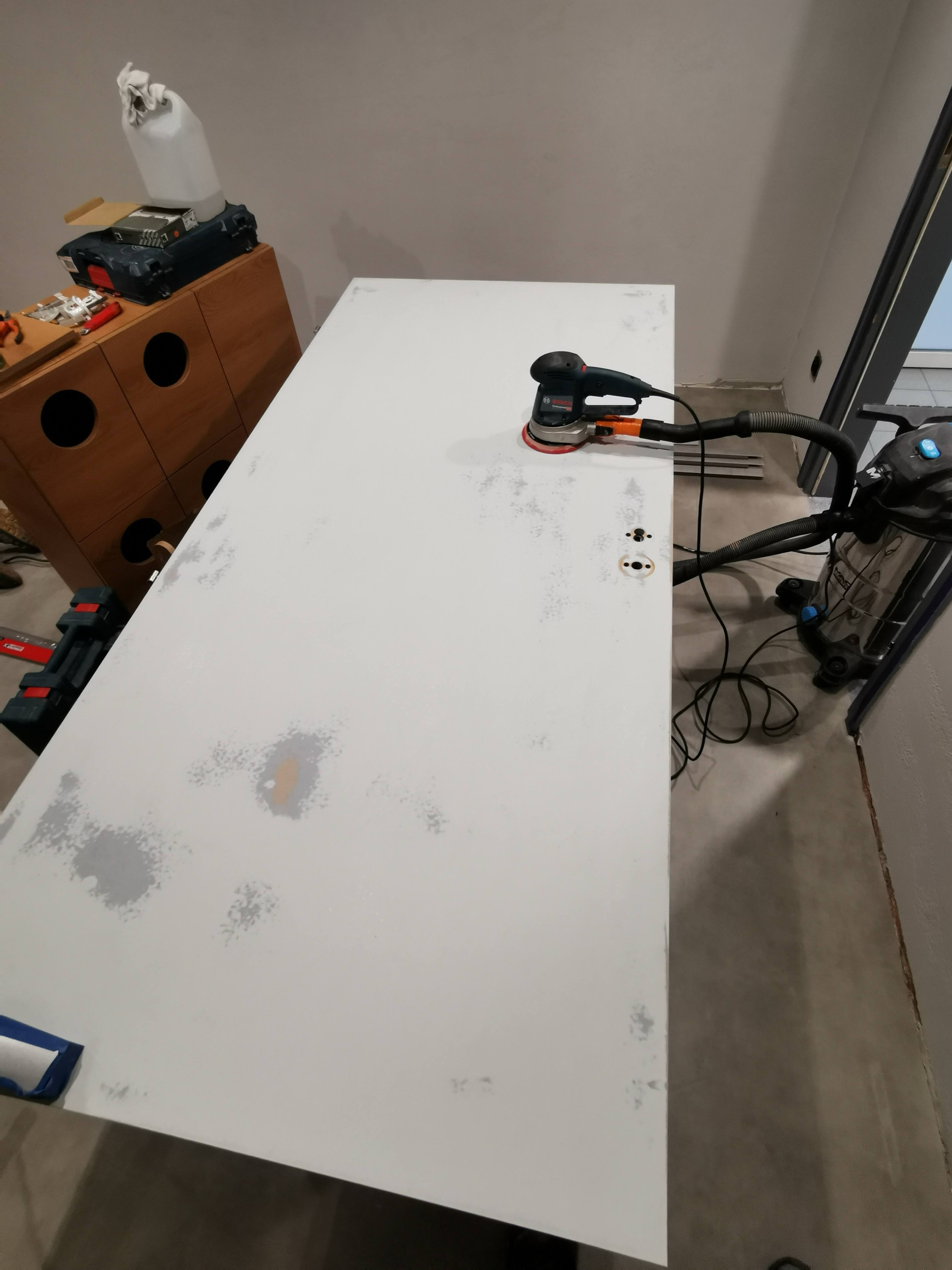 Biały blat roboczy z elektronarzędziami.