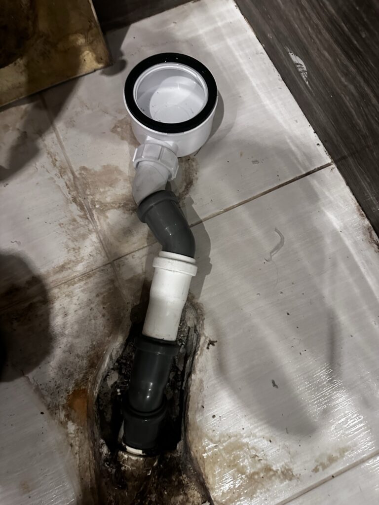 Rura odpływowa podłączona do instalacji w podłodze.