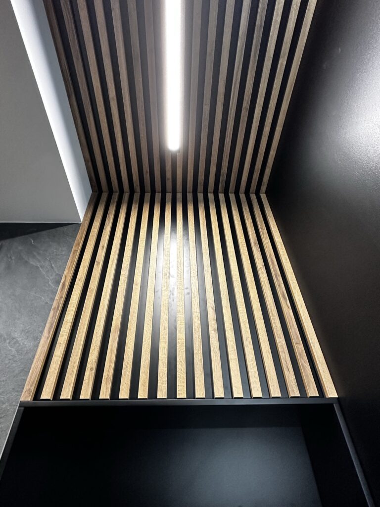 Drewniane listwy z pionowym oświetleniem LED.