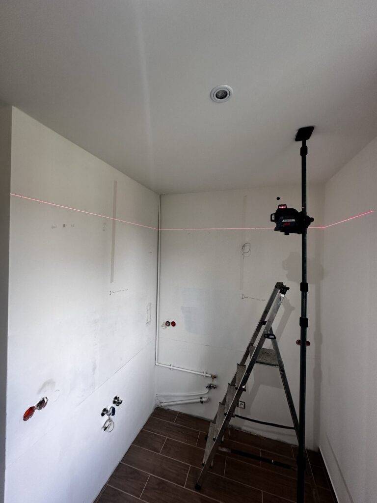 Drabina pod zamontowaną lampą w remontowanym pokoju.