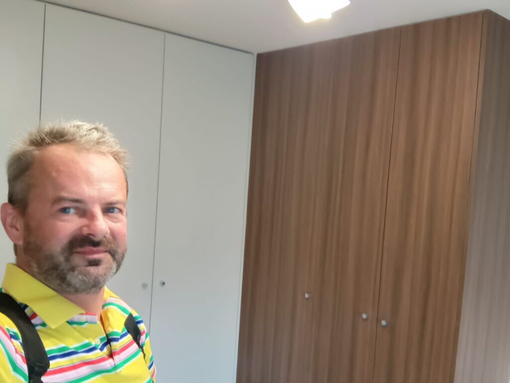 Mężczyzna w pokoju z nową zabudową szaf.