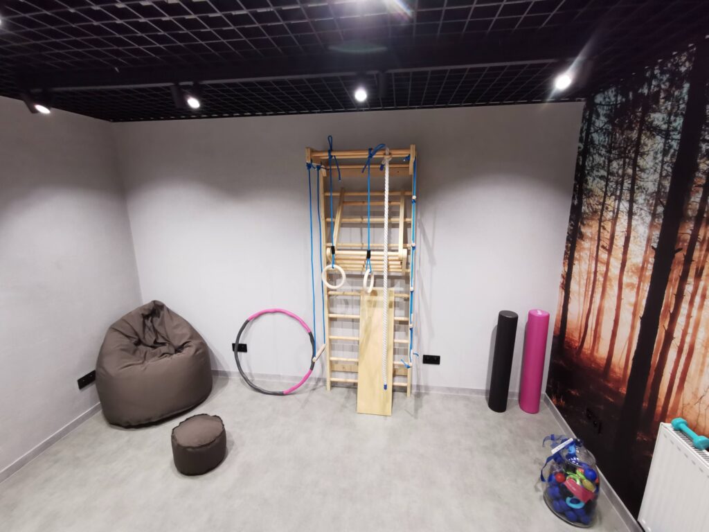Sala z drabinką gimnastyczną, hula-hop i workiem sako.