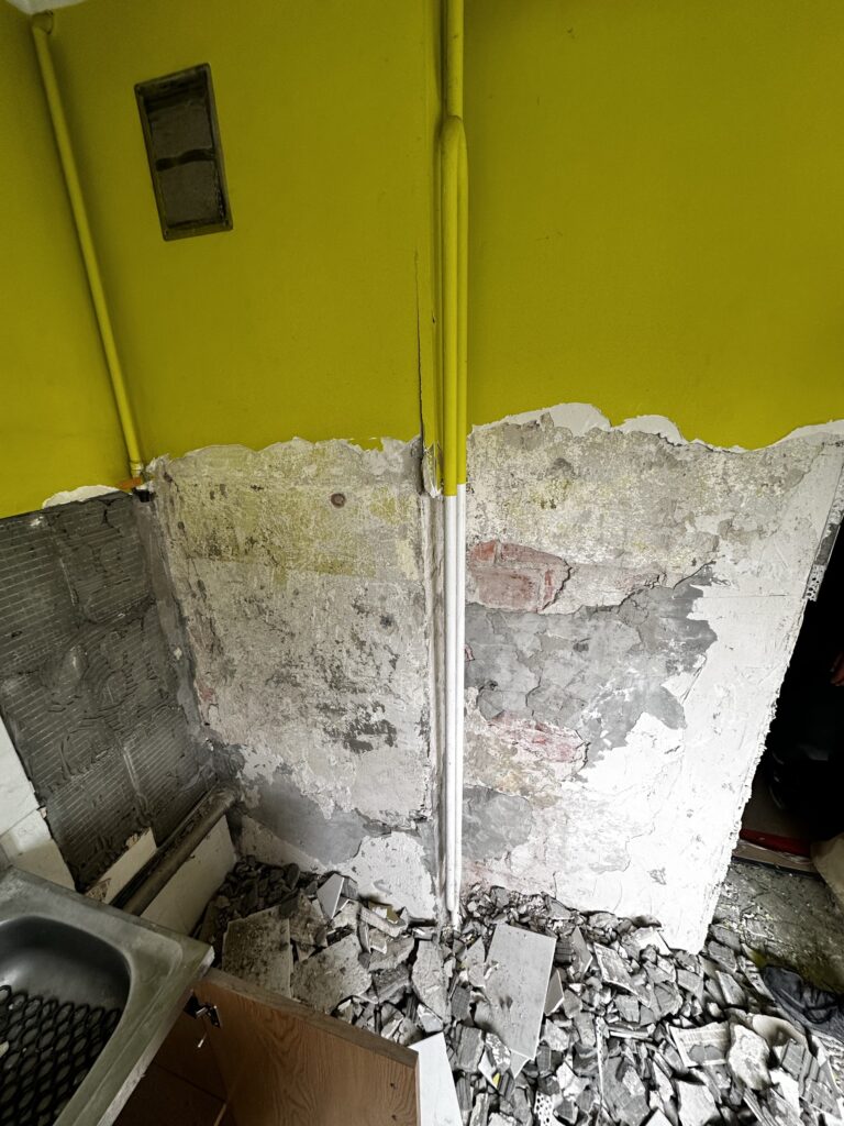 Odsłonięta ściana z przewodem instalacyjnym.