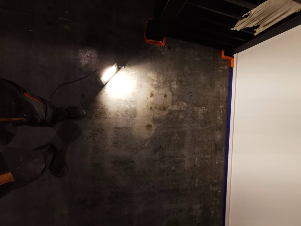 Ciemna betonowa podłoga oświetlona lampą roboczą.