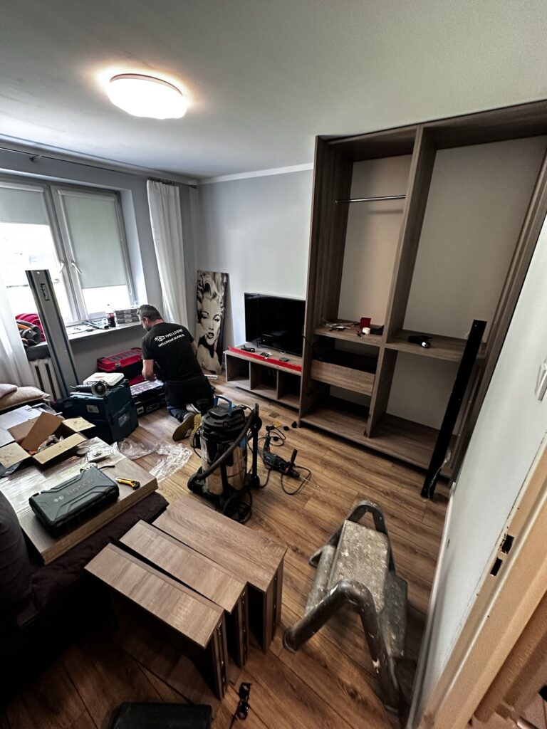 Pokój z telewizorem i montowaną zabudową ścienną.