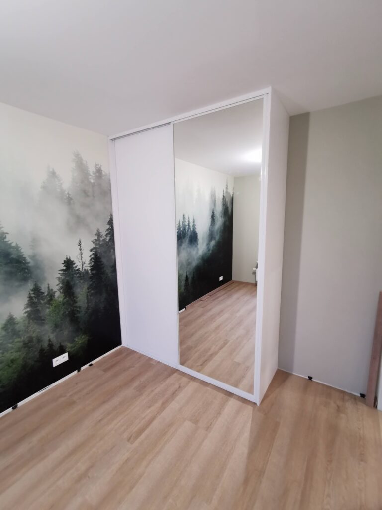 Biała szafa z lustrzanymi drzwiami przy leśnej fototapecie