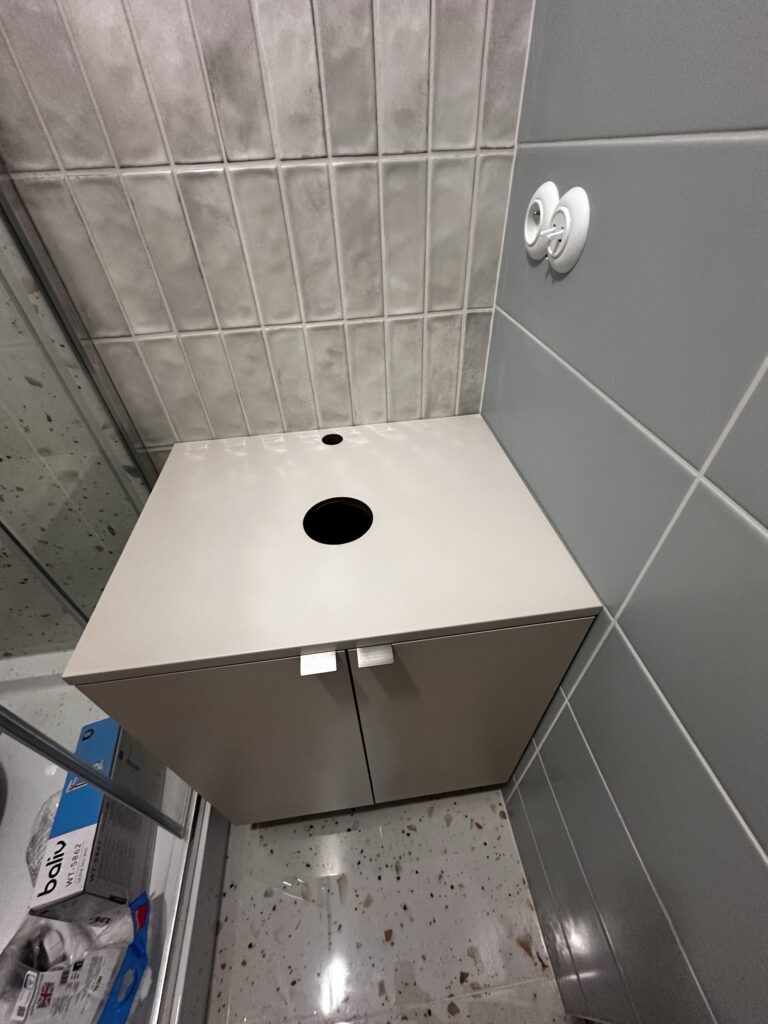 Szafka pod umywalkę z otworem w blacie.
