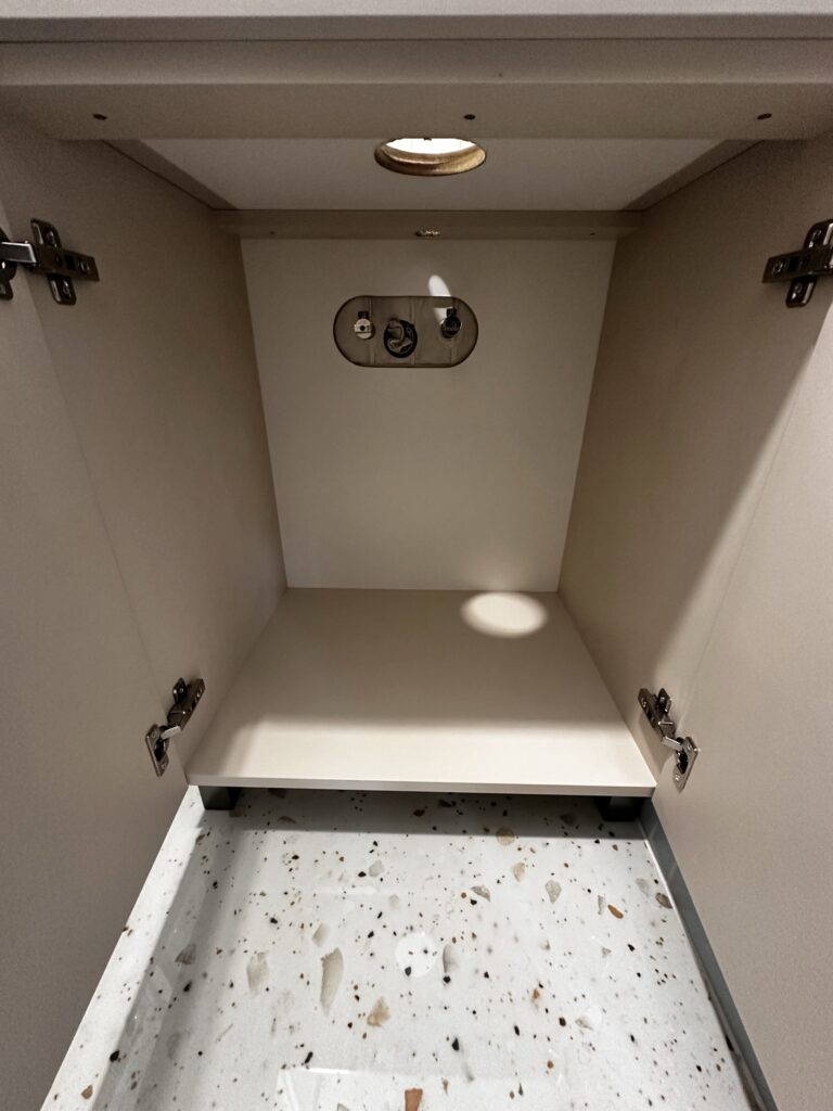 Wnętrze szafki z zawiasami i prowadnicami.