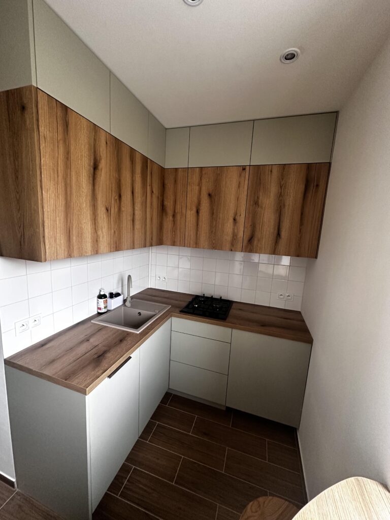 Niewielka kuchnia z drewnianą zabudową.