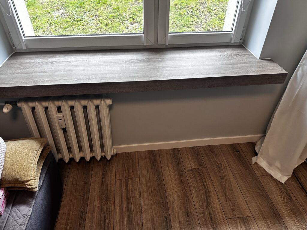 Parapet nad grzejnikiem przy oknie.