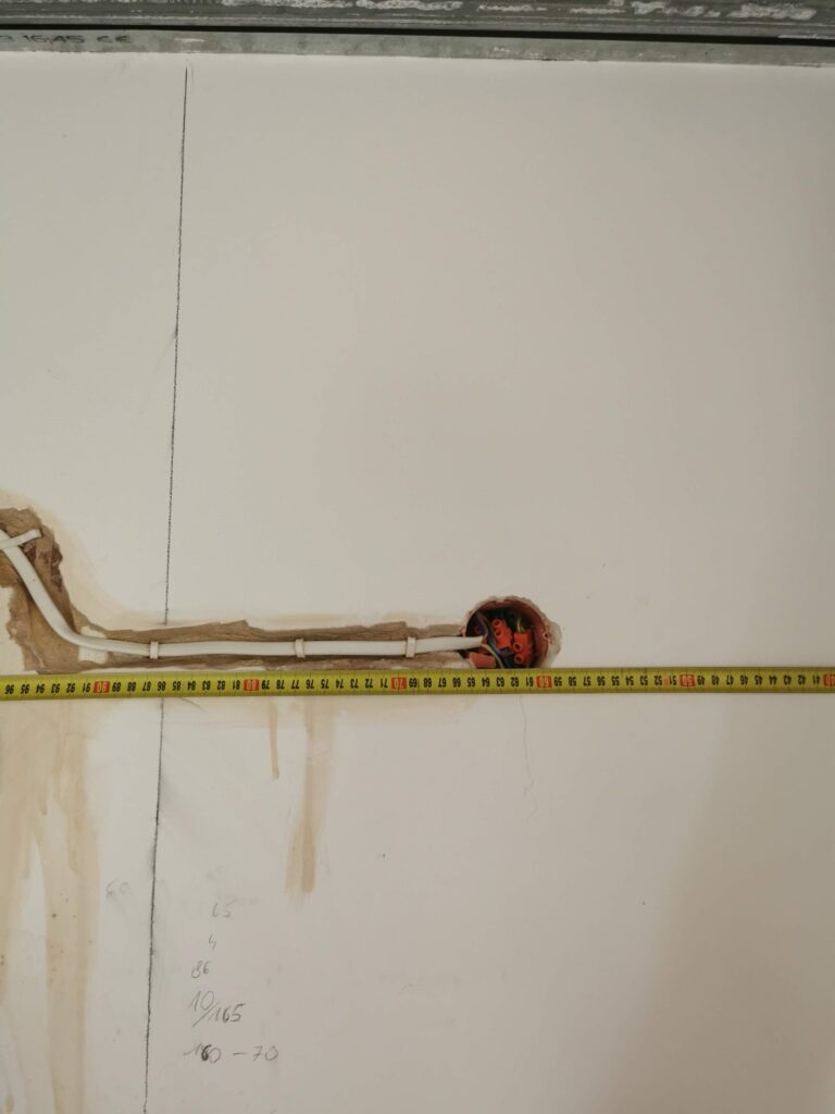 Otwór instalacyjny w ścianie mierzonej miarką