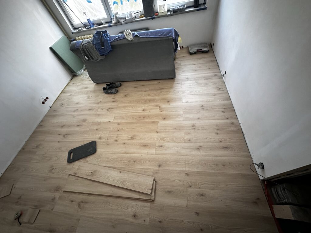 Panele podłogowe z narzędziami podczas montażu.