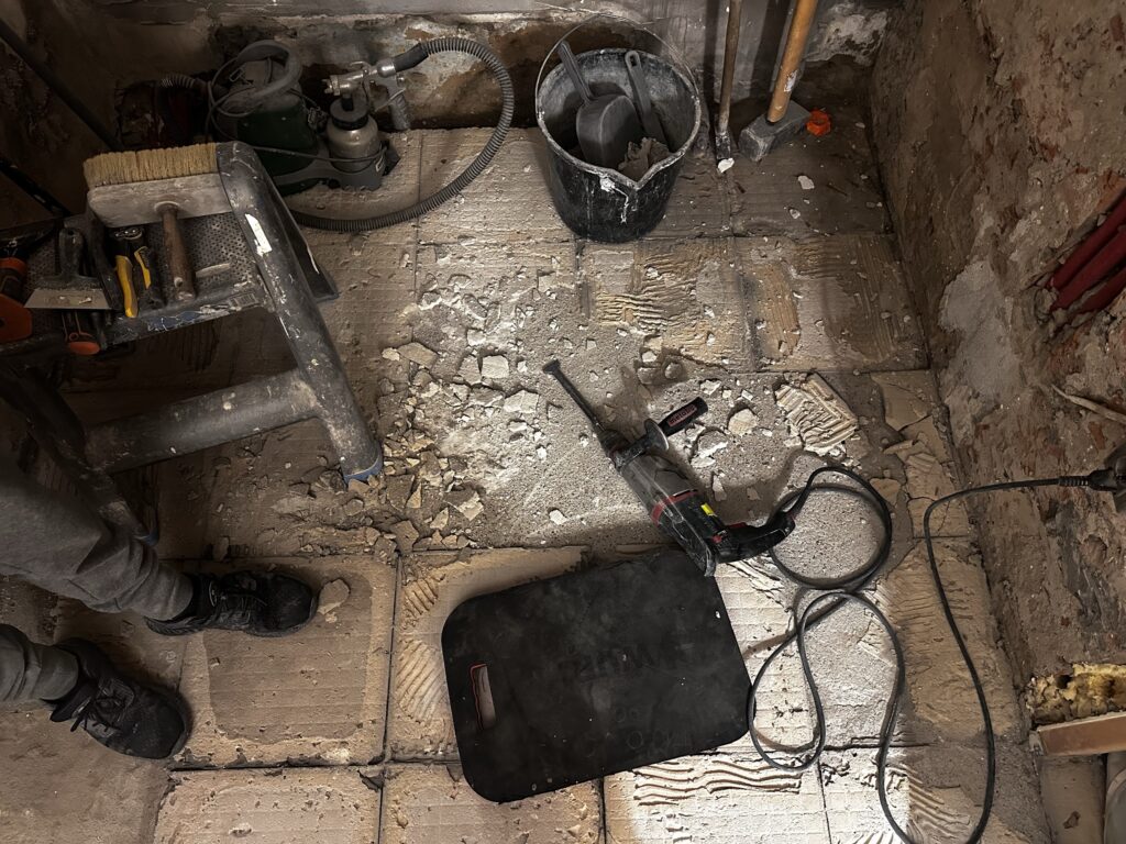 Rozkuta podłoga z rurami i przewodami instalacyjnymi.