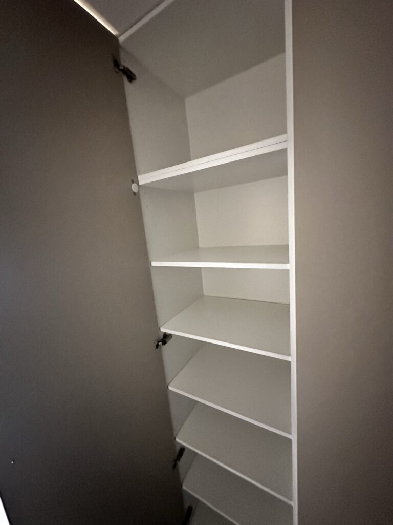 Biała szafa z otwartymi półkami.