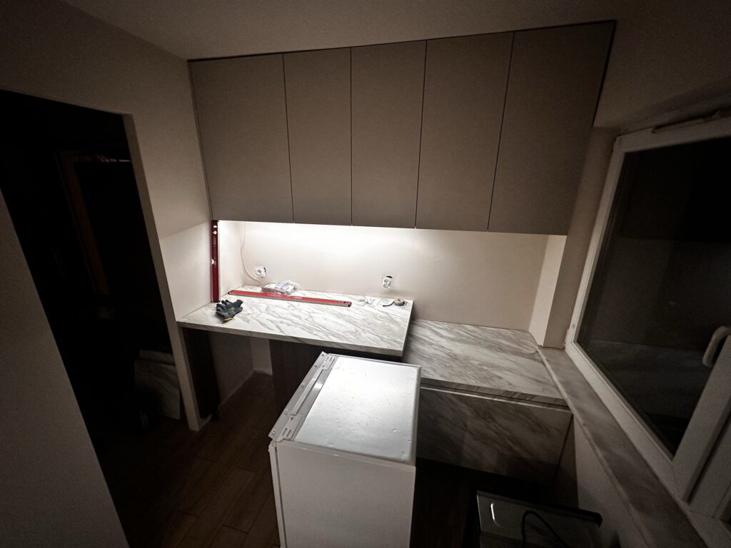 Górne szafki kuchenne nad marmurowym blatem.
