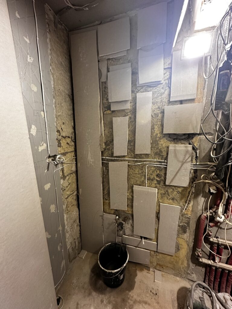 Odsłonięta instalacja wodna w rozebranej ścianie łazienki.