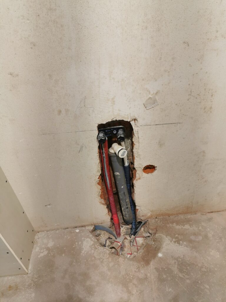 Odsłonięta instalacja wodna w ścianie podczas remontu