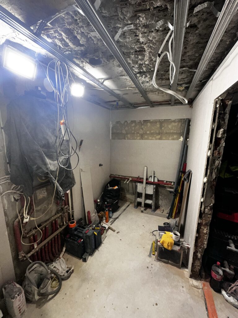 Pomieszczenie techniczne z odsłoniętymi przewodami i instalacją.