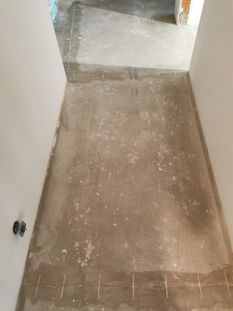 Wąski korytarz z surową betonową podłogą