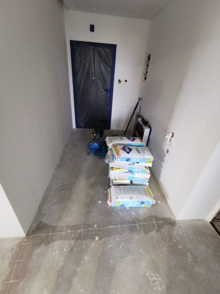 Materiały budowlane ułożone w korytarzu podczas remontu