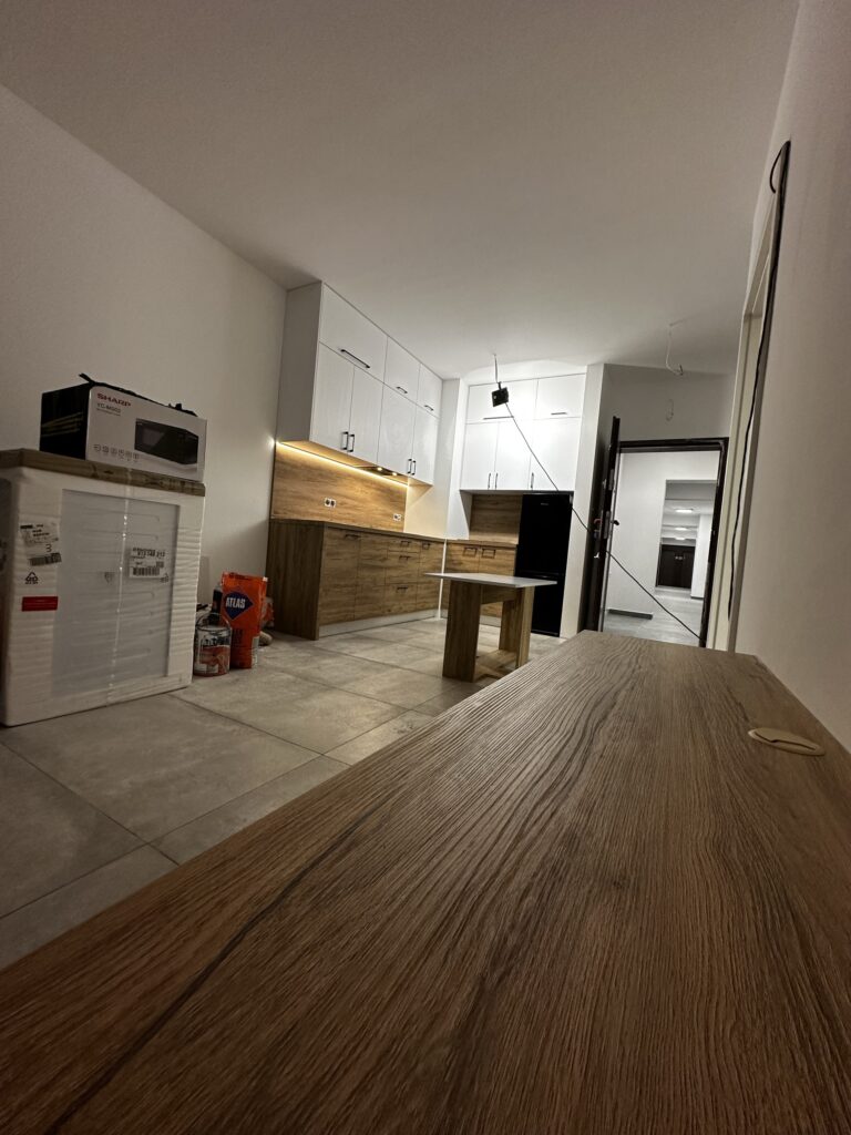 Kuchnia z drewnianym blatem i białą zabudową