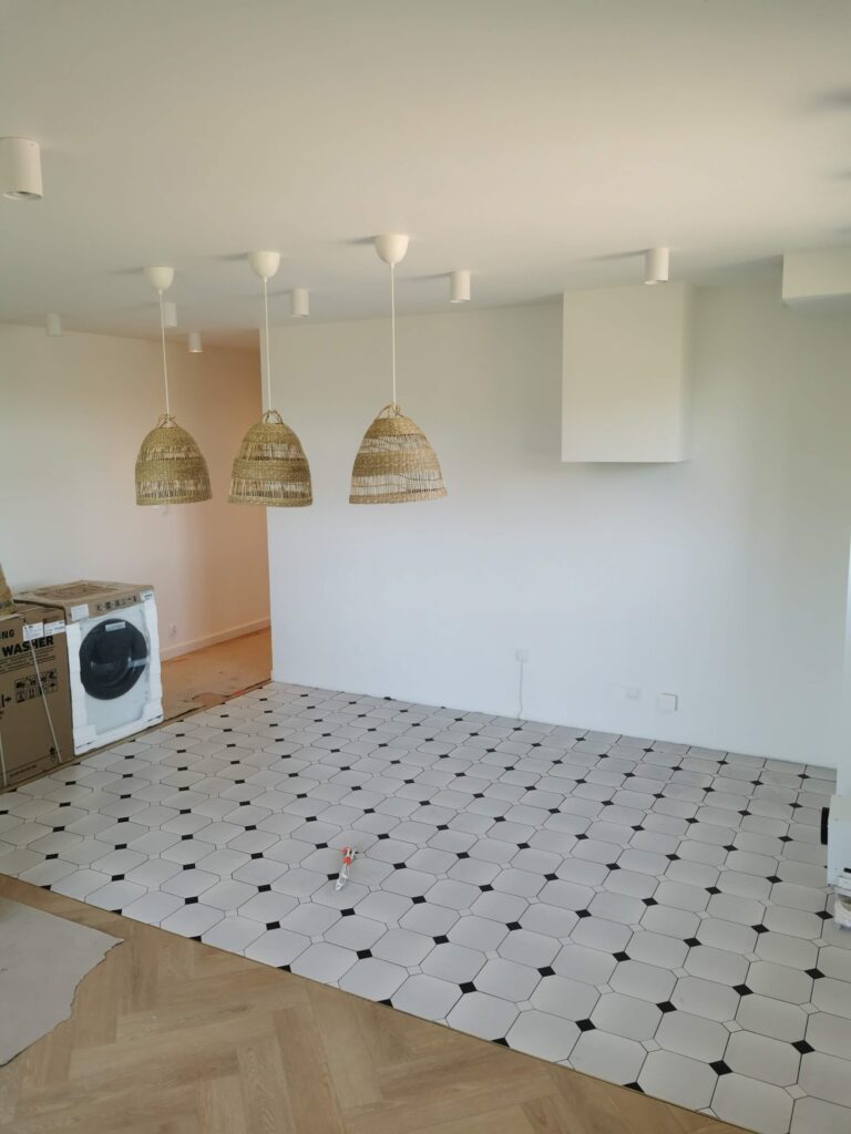 Pusta przestrzeń z geometryczną podłogą i trzema plecionymi lampami