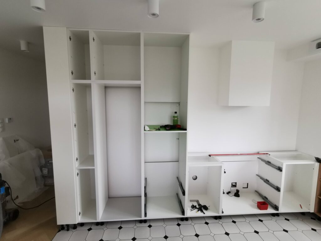 Otwarte korpusy białych szafek kuchennych przed zamontowaniem frontów