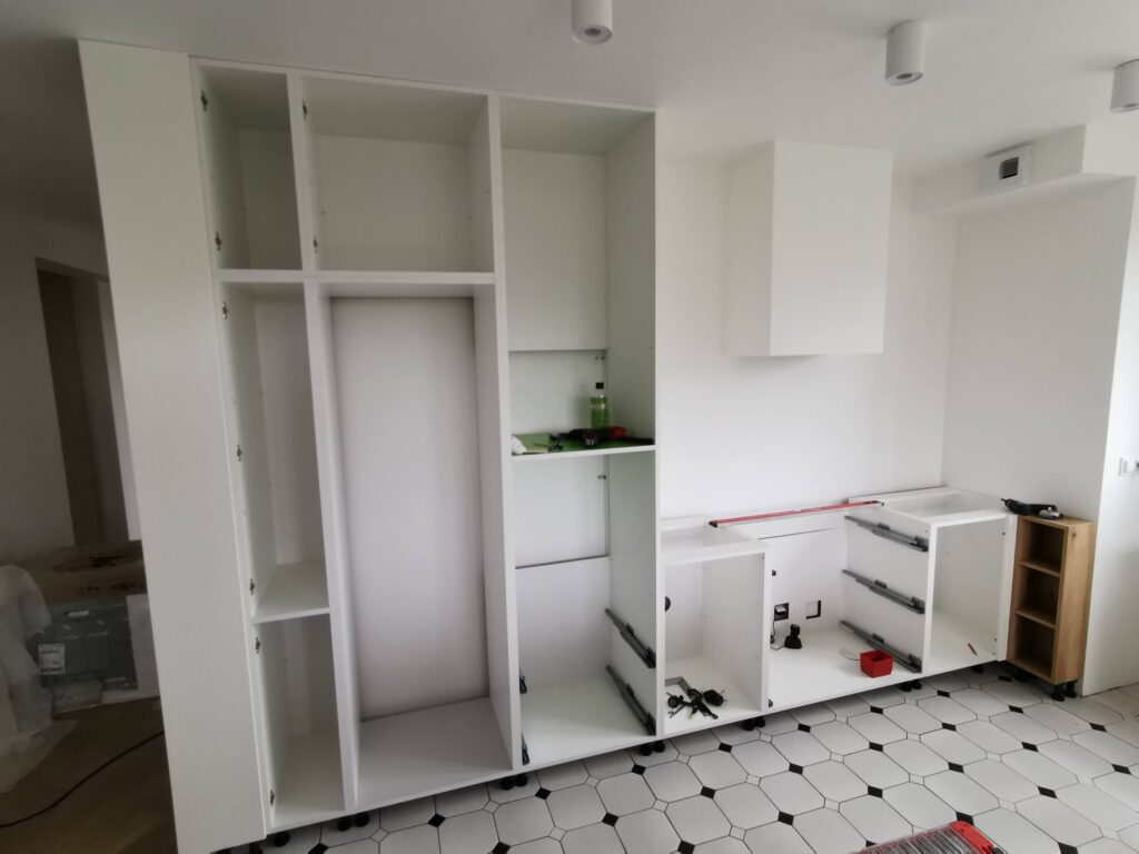 Białe korpusy szafek kuchennych przygotowane do dalszego montażu