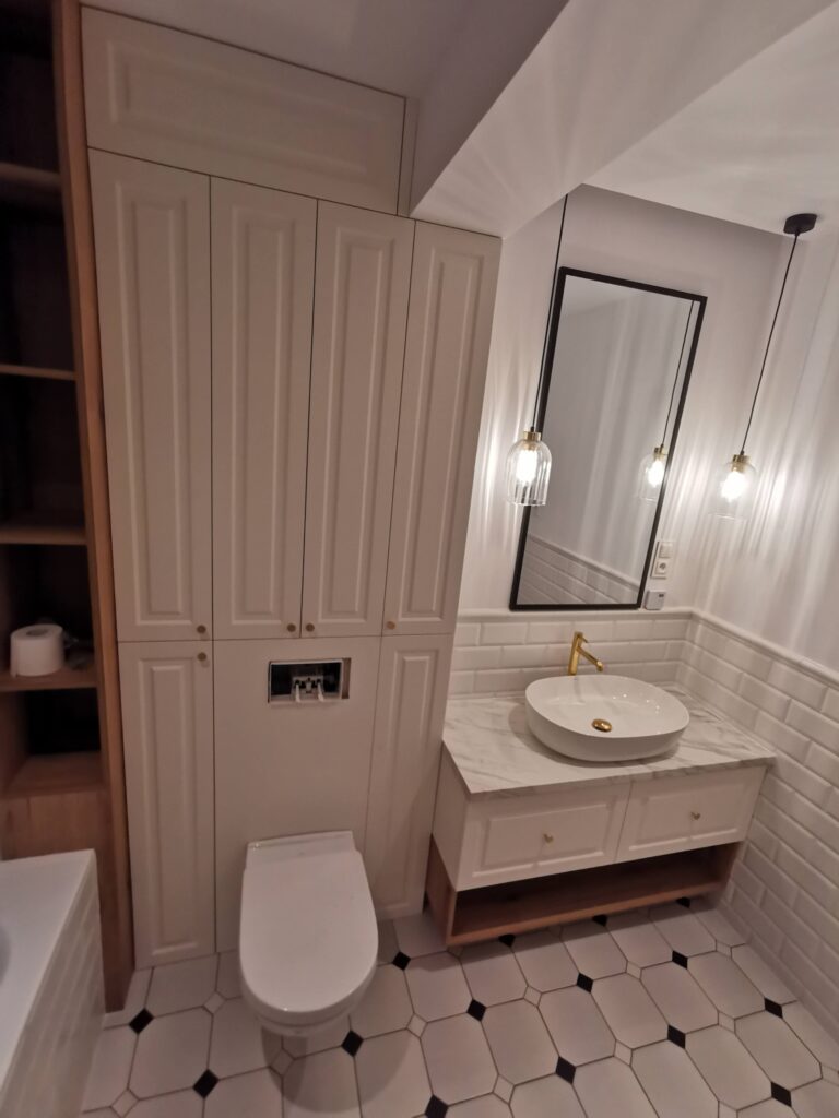 Toaleta i umywalka nablatowa pod lustrem oraz wiszącymi lampami