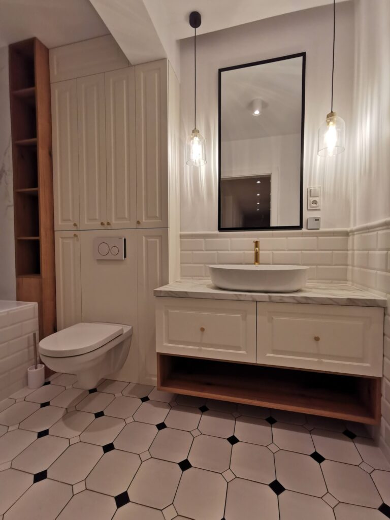 Biała łazienka z toaletą, umywalką, lustrem i wiszącymi lampami